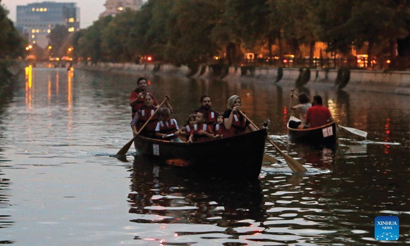 People row boats on a river during the Dambovita Delivery cultural event, in Bucharest, Romania, Sept. 17, 2021. The event, at its first edition, aims to bring the community closer to Bucharest's river, by organizing educational, cultural and sportive activities on the water and its neighborhoods.Photo:Xinhua