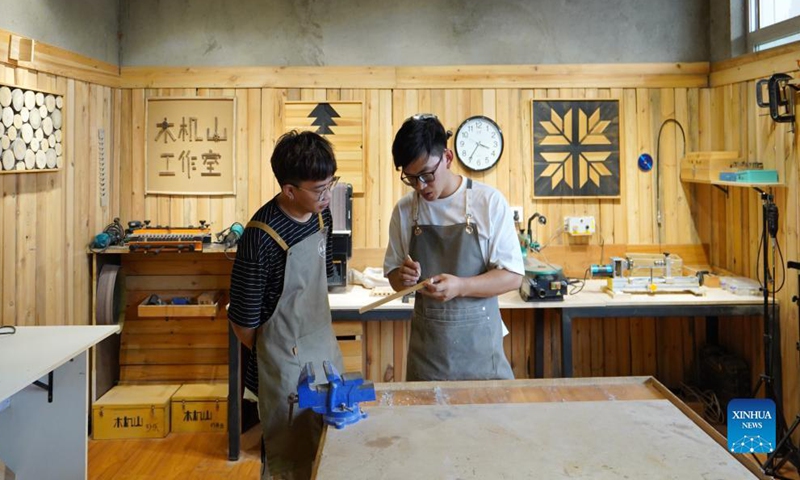 Li Zhanlong shows a wooden mechanical installation at his studio in Luquan District of Shijiazhuang, north China's Hebei Province, Sept. 14, 2021. Li Zhanlong is a wooden mechanical installation designer in Shijiazhuang. After graduation, Li once worked as a salesman and ran an online shop. In 2018, Li Zhanlong left his job and went to Tianjin to learn carpentry skills. Photo: Xinhua