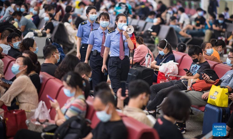 Staff members of Hankou Railway Station remind passengers to follow epidemic prevention rules in Wuhan, central China's Hubei Province, Sept. 19, 2021, the first day of the 3-day Mid-Autumn Festival holiday. (Photo:Xinhua)