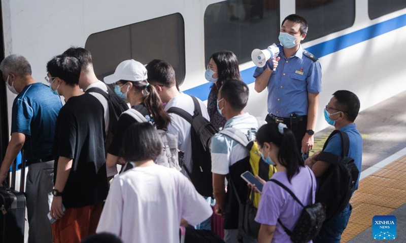 A staff member of Hankou Railway Station guides passengers on the platform in Wuhan, central China's Hubei Province, Sept. 19, 2021, the first day of the 3-day Mid-Autumn Festival holiday. (Photo:Xinhua)