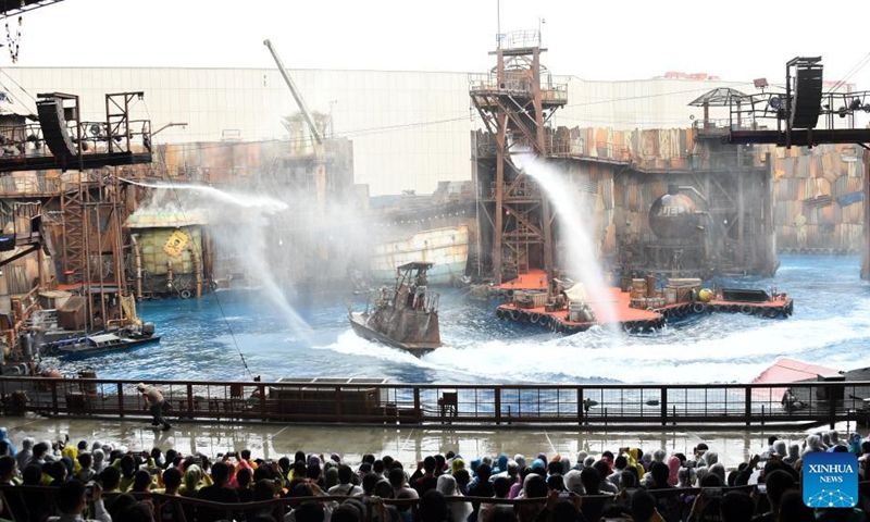 Tourists watch a stunt performance at the theme land of WaterWorld at the Universal Beijing Resort in Beijing, capital of China, Sept. 20, 2021. The Universal Beijing Resort, currently the largest in scale worldwide, opened to the public on Monday. The resort, covering 4 square km, includes the highly anticipated Universal Studios Beijing theme park, the Universal CityWalk, and two hotels. (Photo: Xinhua)