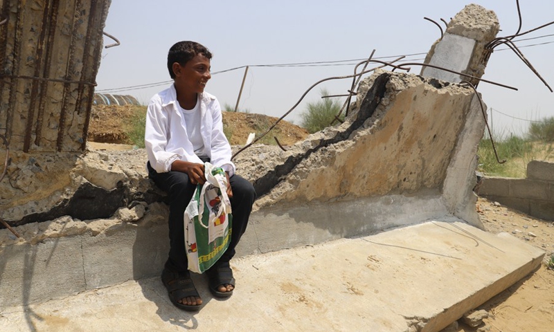 A boy sits at the ruins of school buildings at a primary school, which has tents, straw huts and wooden cabins as classrooms, in Hajjah Province, Yemen, Sept. 20, 2021.(Photo: Xinhua)