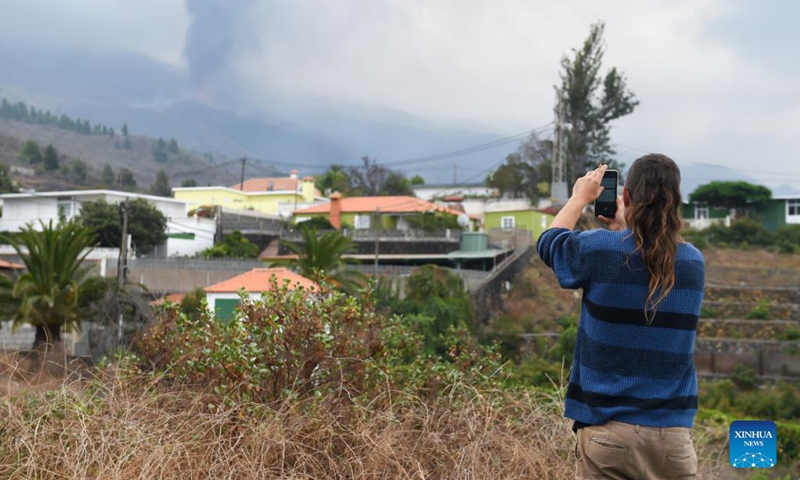 A resident takes pictures of the eruption of the Cumbre Vieja volcano on the island of La Palma in the Canary Islands, Spain, on Sept. 21, 2021. The eruption of the Cumbre Vieja volcano is expected to last between 24 and 84 days, the Volcanology Institute of the Canary Islands (INVOLCAN) said on Wednesday.(Photo: Xinhua)