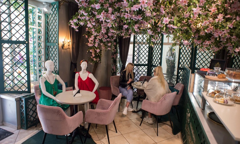 Customers dine beside mannequins dressed in creations of local designers in a cafe in the Old Town of Vilnius, Lithuania, on May 21, 2020. (Photo: Xinhua)