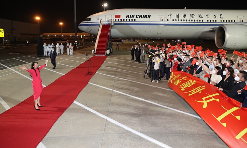 Meng waves to the crowd after her arrival at the Shenzhen Bao'an International Airport.(Photo: Xinhua)