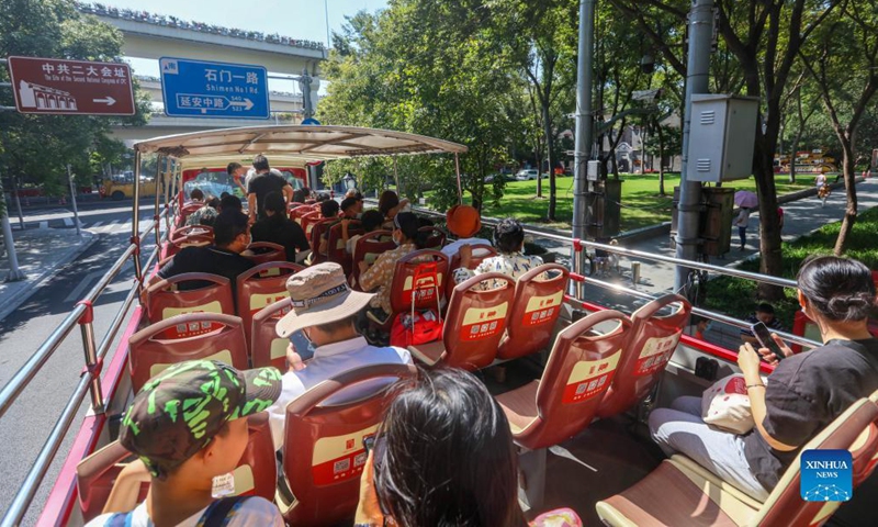 Tourists take a special hop-on hop-off bus which travels between landmark red sites in east China's Shanghai, Oct. 3, 2021.  (Xinhua/Wang Xiang)