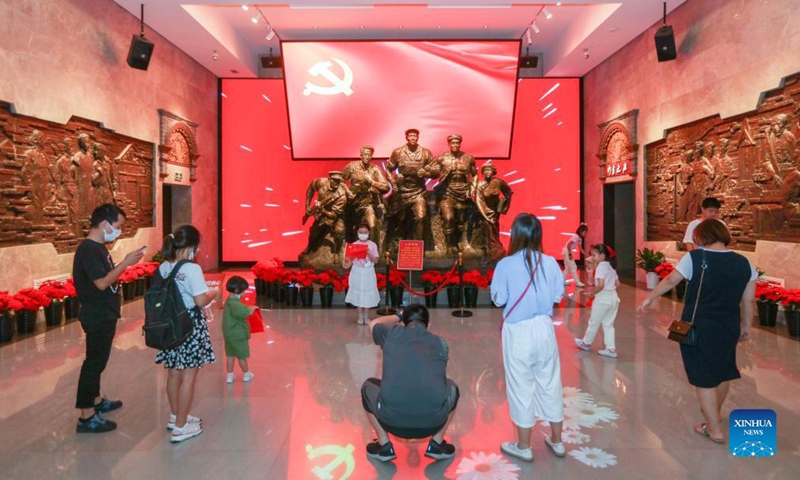 Tourists take photos at the memorial of the fourth National Congress of the Communist Party of China (CPC) in east China's Shanghai, Oct. 3, 2021. East China's Shanghai is home to many landmark sites which bear witness to the CPC history and the CPC revolutionary activities. As red tourism becomes increasingly popular, the city has launched a special hop-on hop-off bus service that provides more fun to travel between five notable red sites during the National Day holiday. (Xinhua/Wang Xiang)