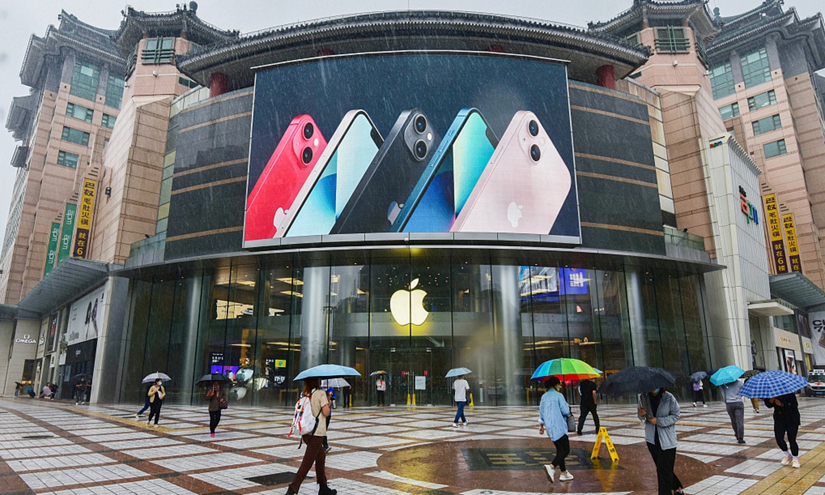 On September 24, 2021, people walk past an apple store in Wangfujing, Beijing, with iPhone 13 series advertisement on a big screen. Photo: CFP