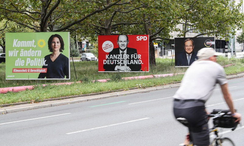 A cyclist rides past election posters of Chancellor candidates (from L to R) Annalena Baerbock of the Green Party, Olaf Scholz of German Social Democratic Party (SPD) and Armin Laschet of German Christian Democratic Union (CDU)/Christian Social Union (CSU) in Berlin, capital of Germany, on Sept. 25, 2021.(Photo: Xinhua)
