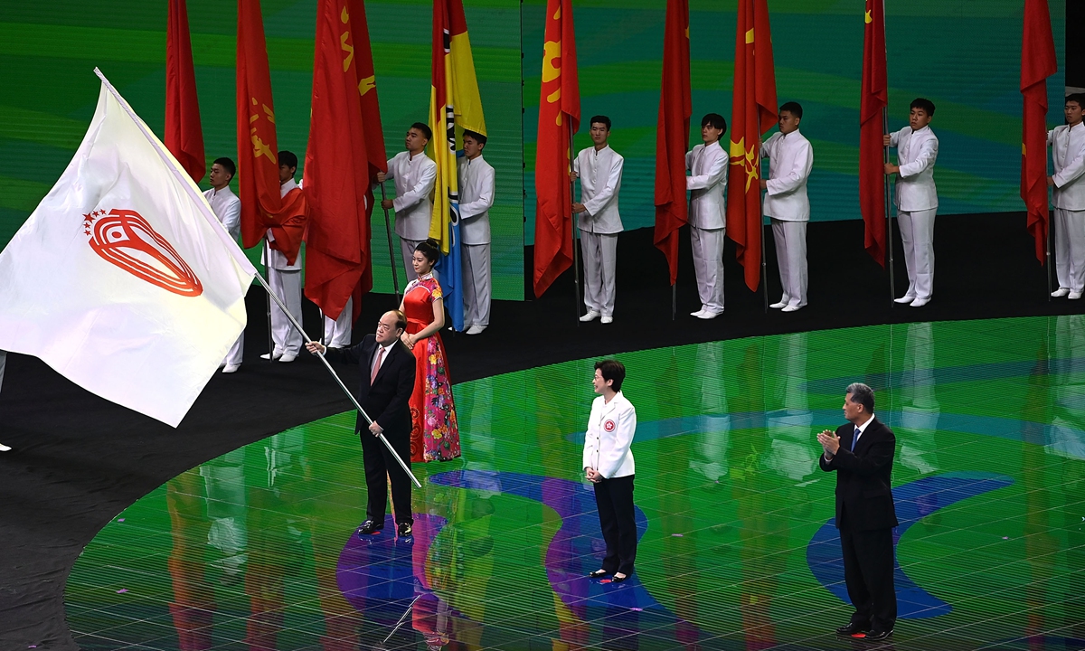 Chief Executive of the Macao Special Administrative Region (SAR) Ho Iat-seng (left) waves the flag of the National Games of the People’s Republic of China on Monday at the closing ceremonies of the 14th National Games in Xi’an, Northwest China’s Shaanxi Province, with Hong Kong SAR Chief Executive Carrie Lam and South China’s Guangdong Province Governor Ma Xingrui looking at him. Guangdong, Hong Kong and Macao will jointly host the 15th National Games in 2025.  Photo: AFP
