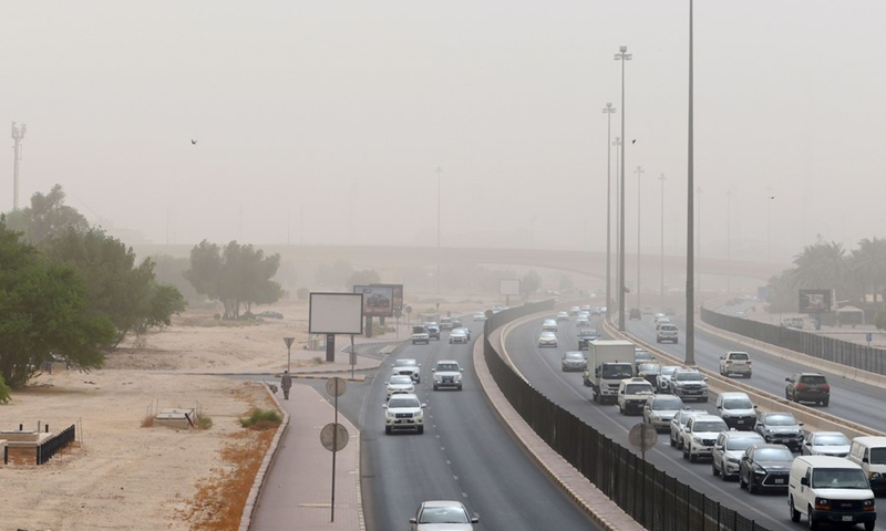 Photo taken on Sept. 26, 2021 shows cars driving in heavy dust in Kuwait City, Kuwait. A heavy sand storm engulfed Kuwait on Sunday.(Photo: Xinhua)