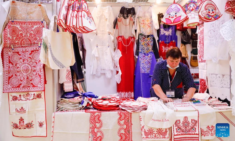 An exhibitor arranges her products at the Firebird exhibition and fair, an annual event for folk craftsmen and artisans from Russia, in Moscow, Russia, on Sept. 29, 2021.Photo:Xinhua