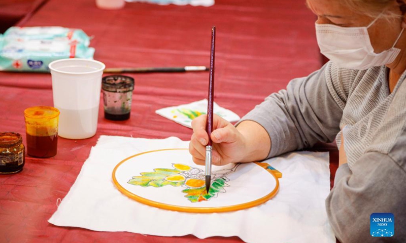 A woman paints on a piece of cloth at the Firebird exhibition and fair, an annual event for folk craftsmen and artisans from Russia, in Moscow, Russia, on Sept. 29, 2021.Photo:Xinhua