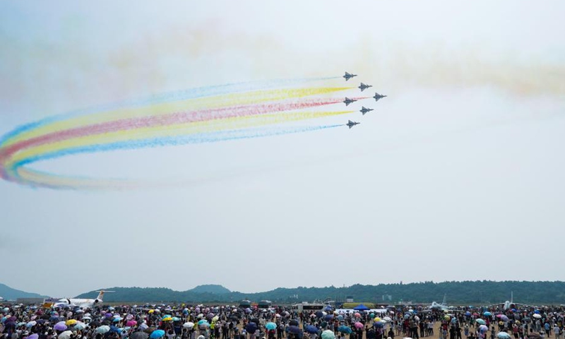 Visitors view performance by China's Bayi Aerobatic Team during the 13th China International Aviation and Aerospace Exhibition, or Airshow China 2021, in Zhuhai, south China's Guangdong Province, Oct. 1, 2021.Photo:Xinhua
