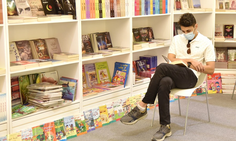 التقطت الصورة في 1 أكتوبر 2021 تظهر رجلاً يقرأ الكتب في معرض الكتاب الدولي في الرياض بالمملكة العربية السعودية.  (الصورة: شينهوا)