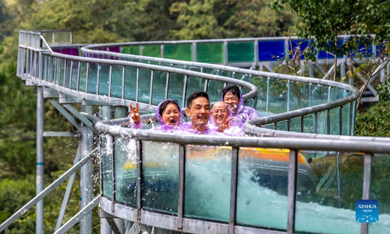 Tourists enjoy themselves on a glass-bottomed slide at the Great Nanjiang Canyon in Kaiyang County, southwest China's Guizhou Province, Oct. 2, 2021. Saturday was the second day of China's week-long National Day holiday.(Photo: Xinhua)
