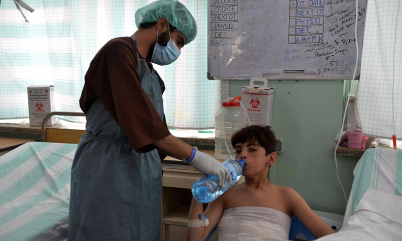 A doctor gives water to a child at the Mirwais Regional Hospital in Kandahar city, southern Afghanistan, Sept. 30, 2021.(Photo: Xinhua)