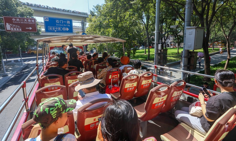 Tourists take a special hop-on hop-off bus which travels between landmark red sites in east China's Shanghai, Oct. 3, 2021. (Photo: Xinhua)