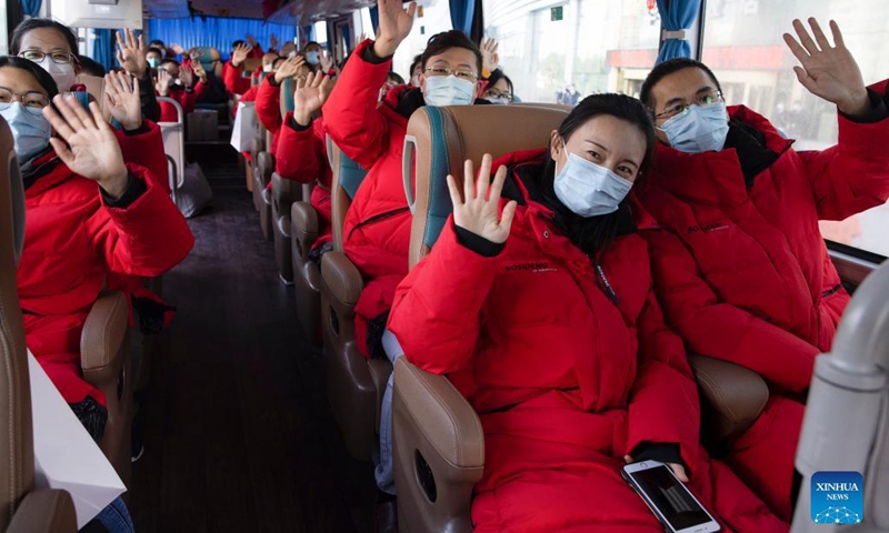 Medical workers from Hebei Province wave goodbye on a returning bus in Harbin, northeast China's Heilongjiang Province, Oct. 4, 2021. A total of 266 medical workers from Hebei and Jilin provinces who came to aid Harbin in nucleic acid testing left the city on Monday after finishing their work. (Xinhua/Zhang Tao)