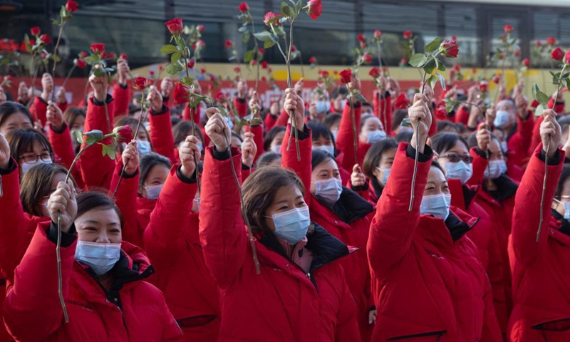 Medical workers from Jilin Province wave at a farewell ceremony in Harbin, northeast China's Heilongjiang Province, Oct. 4, 2021. A total of 266 medical workers from Hebei and Jilin provinces who came to aid Harbin in nucleic acid testing left the city on Monday after finishing their work. (Xinhua/Zhang Tao)
