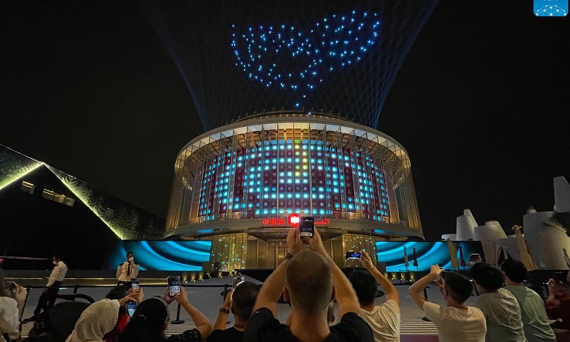 People take pictures of the light show at the China Pavilion of Expo 2020 Dubai in Dubai, the United Arab Emirates, Oct. 4, 2021. Covering an area of 4,636 square meters, the China Pavilion is one of the largest at the expo. Featuring a lantern-shaped design, the pavilion is called The Light of China, symbolizing hope and a bright future. (Xinhua/Su Xiaopo)