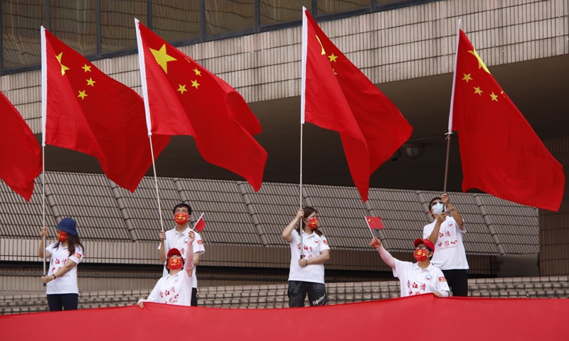 Hong Kong residents wave the Chinese national flags in Tsim Sha Tsui, south China's Hong Kong, Oct. 1, 2021. (Xinhua/Zhang Jiayi)