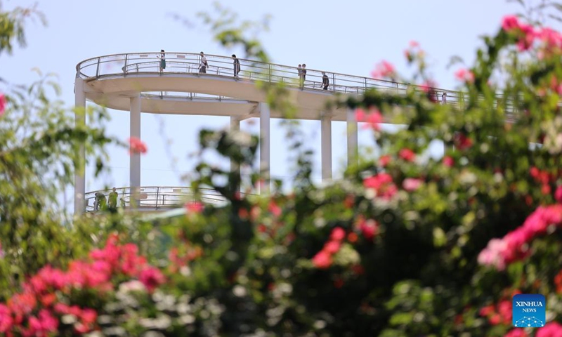 Photo taken on Oct. 5, 2021 shows people walking on a skywalk in Xiamen, southeast China's Fujian Province. Outdoor public places in Xiamen started to reopen from Oct. 5, as the results of the sixth round of citywide nucleic acid testing all came out negative. (Photo:Xinhua)