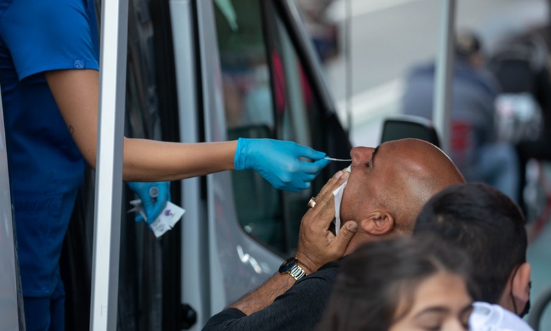 A man takes a COVID-19 test at a testing van in Times Square in New York, the United States, Oct. 2, 2021.(Photo: Xinhua)
