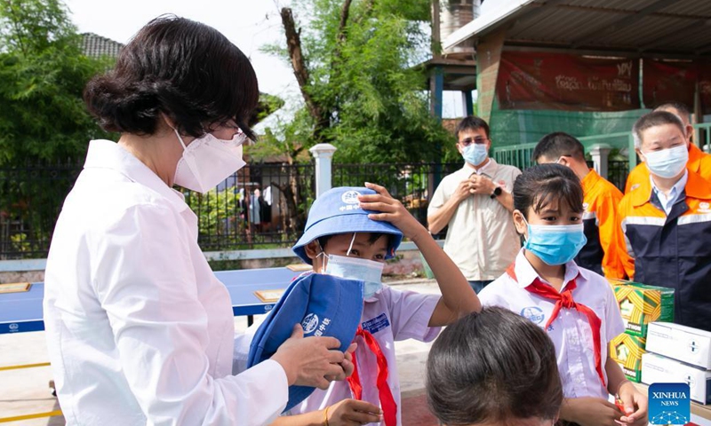 A representative with the China-Laos railway engineering companies, including the China Railway International Group (CRIG) and the China Railway No.2 Engineering Group (CREC-2), hands over gifts to the pupils of the China-Laos Friendship Nongping Primary School in Vientiane, Laos, Oct. 8, 2021.Photo:Xinhua