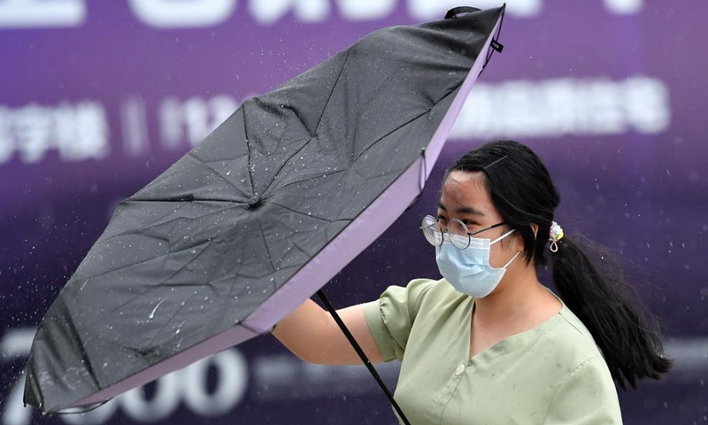 A pedestrian's umbrella is blown inside out by strong wind in Haikou, capital of south China's Hainan Province, Oct. 8, 2021.Photo:Xinhua