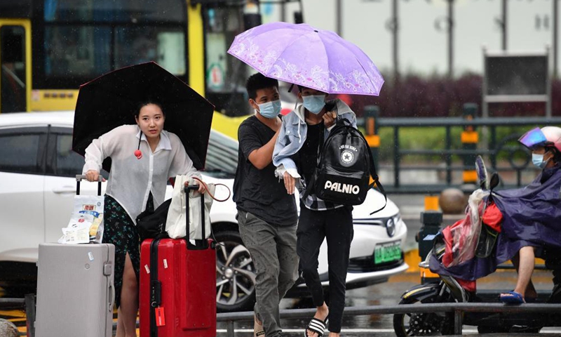 People walk in rain in Haikou, capital of south China's Hainan Province, Oct. 8, 2021.Photo:Xinhua