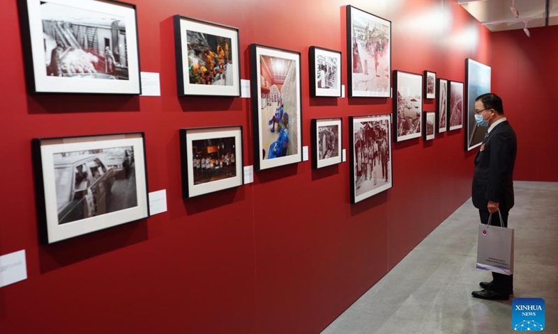 A guest visits a photo exhibition at Hong Kong Central Library in Hong Kong, south China, Oct. 8, 2021. A photo exhibition that opened Friday in Hong Kong showcased the unfading blood ties between Hong Kong and the motherland over the past 100 years, as well as the great achievements of China.Photo:Xinhua