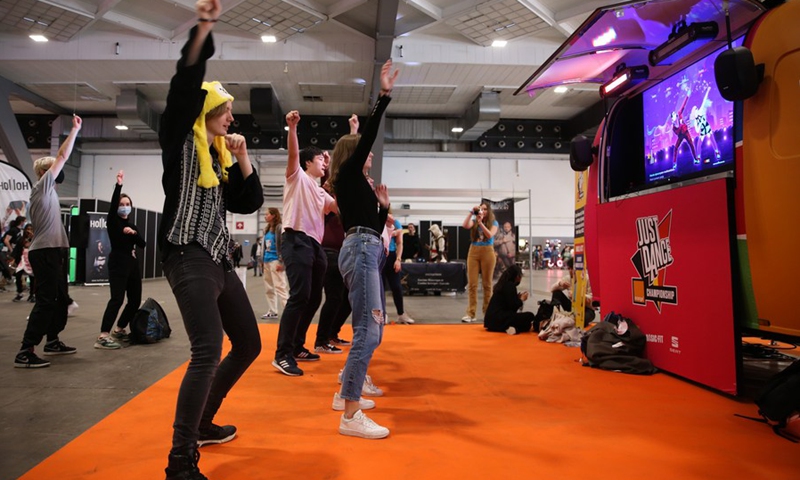 Visitors play video game at the Made in Asia animation and cartoon products fair in Brussels, Belgium, Oct. 8, 2021. (Photo: Xinhua)