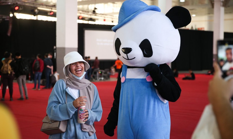 A visitor poses for photo at the Made in Asia animation and cartoon products fair in Brussels, Belgium, Oct. 8, 2021. (Photo: Xinhua)