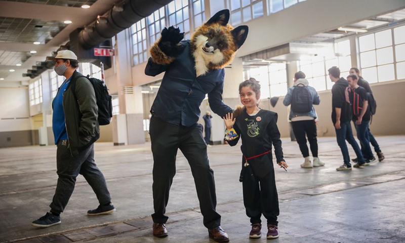 A girl poses for photo with a cosplayer at the Made in Asia animation and cartoon products fair in Brussels, Belgium, Oct. 8, 2021.(Photo: Xinhua)
