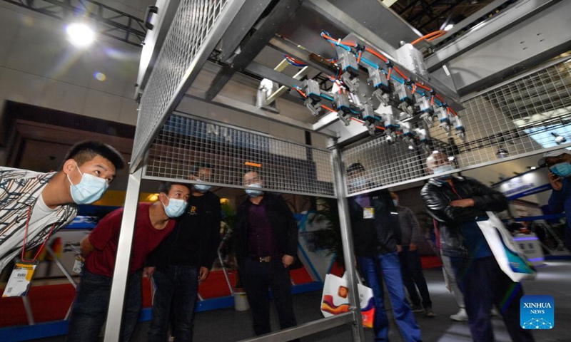 People watch automated equipment for making ice cream during Ice Cream China 2021 held in north China's Tianjin Municipality, Oct. 11, 2021. Ice Cream China 2021 opened Monday in north China's Tianjin Municipality, attracting more than 400 companies and nearly 10,000 buyers. (Xinhua/Sun Fanyue)