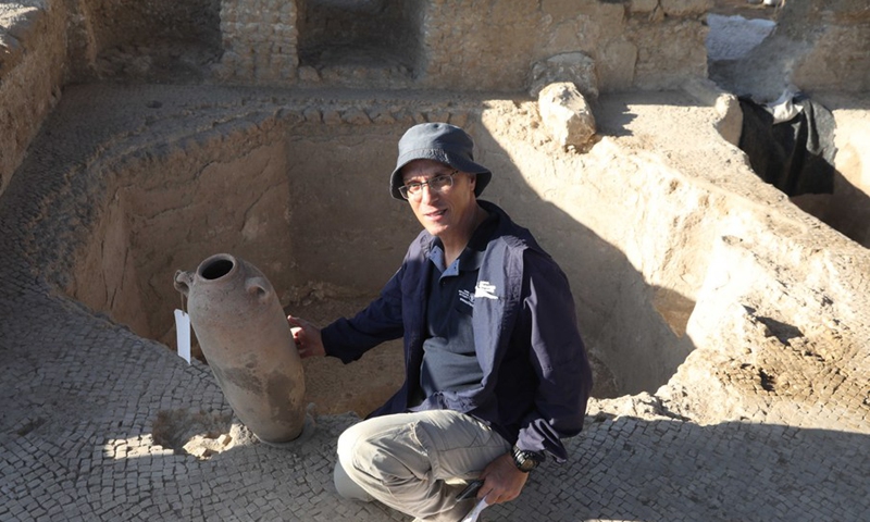 An Israeli archeologist and Yavne Excavation Director Elie Hadad shows the massive winery site in Yavne in central Israel on Oct. 11, 2021.(Photo: Xinhua)
