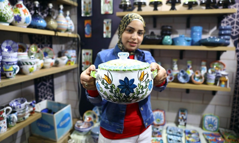 An exhibitor shows a ceramic at a heritage exhibition held in Cairo, Egypt, on Oct. 10, 2021.(Photo: Xinhua)