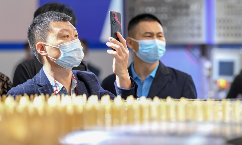 A visitor takes photos during Ice Cream China 2021 held in north China's Tianjin Municipality, Oct. 11, 2021.(Photo: Xinhua)
