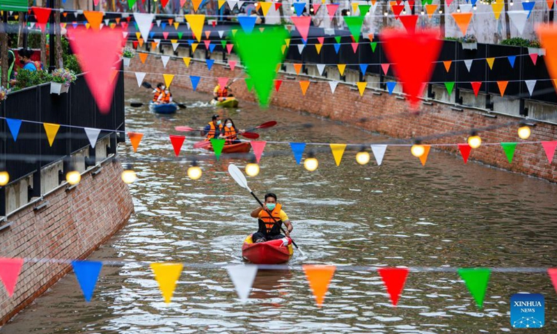 People boat in the canal near the Ong Ang walking street in Bangkok, Thailand, on Oct. 15, 2021. Closed due to the COVID-19 pandemic for several months, the Ong Ang walking street reopened on Friday.Photo:Xinhua