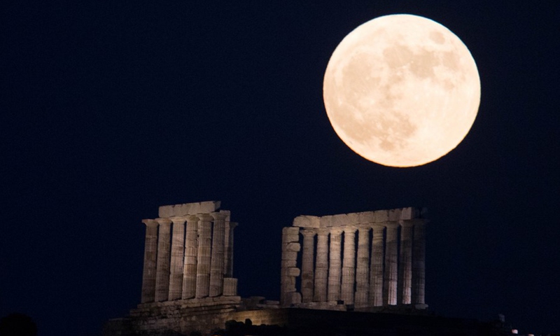The full moon is seen rising over the Temple of Poseidon at cape Sounion, some 70 km southeast of Athens, Greece, on June 24, 2021.(Photo: Xinhua)