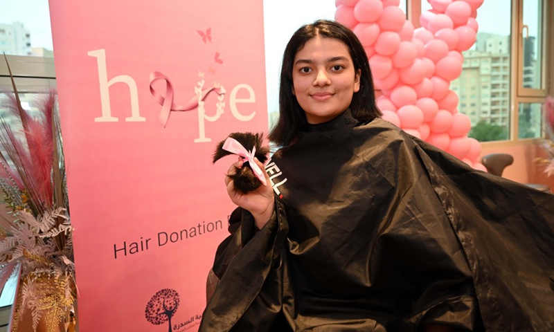 A girl holds her hair during a hair donation event in Hawalli Governorate, Kuwait, on Oct. 19, 2021.(Photo: Xinhua)