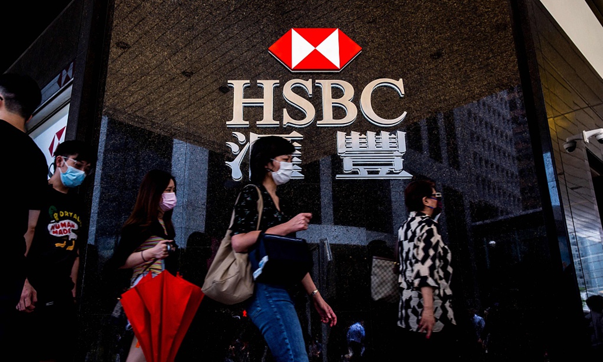 Pedestrians walk past the logo for HSBC outside a local branch bank in Hong Kong on August 2, 2021. Photo: VCG