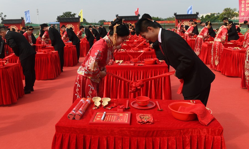 Couples bow to each other during a group wedding at an express railway construction site in Nanning, south China's Guangxi Zhuang Autonomous Region, Oct. 25, 2021.(Photo: Xinhua) 