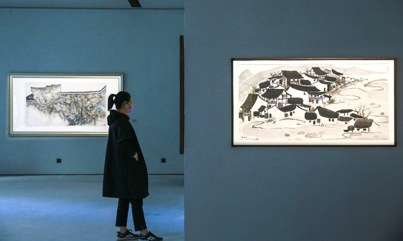 A woman appreciates a painting during the exhibition. Photo: Courtesy of Liu Tao