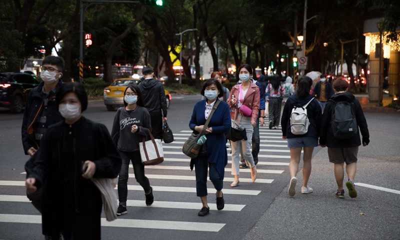 People wearing masks walk on street in Taipei, southeast China's Taiwan, March 30, 2020.(Photo: Xinhua)
