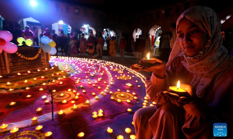 A woman holds oil lamps lit for the upcoming Diwali festival in Bhopal, the capital city of India's Madhya Pradesh, on Oct. 29, 2021. Photo:Xinhua