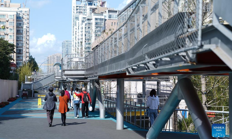 Citizens walk in the Baixi Park in Putuo District of Shanghai, east China, Oct. 31, 2021. Transformed from a market built on an old railway branch line, the Baixi Park is now a city park which provides citizens with space for exercise and entertainment. (Photo: Xinhua)