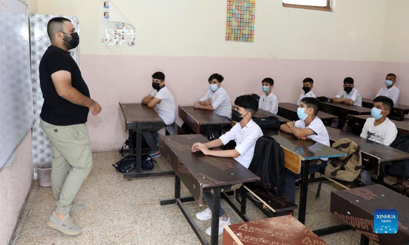 A teacher welcomes the students on the first day of the new school year in Baghdad, Iraq, Nov. 1, 2021.(Photo: Xinhua)