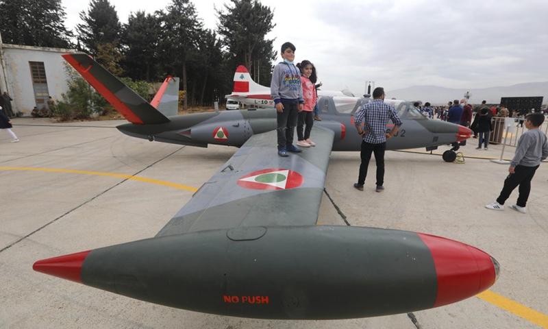 Children stand on a wing of a plane during an open day at Rayak Air Base in Bekaa, Lebanon, on Oct. 31, 2021. (Photo: Xinhua)